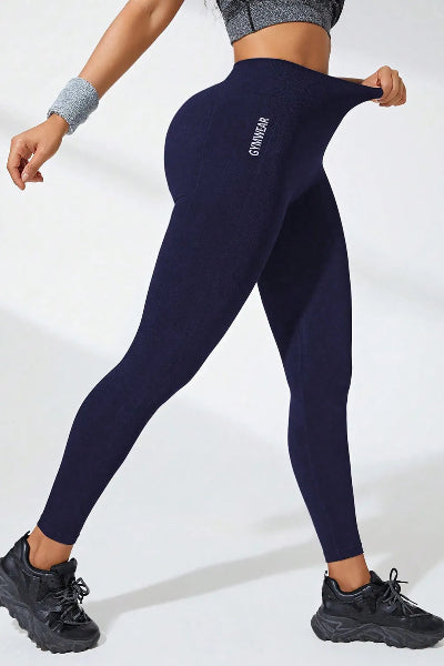 Person wearing navy leggings with a brand logo on a white background