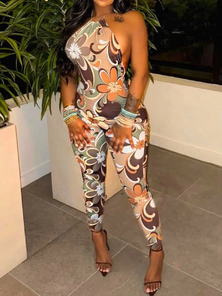 Woman wearing a floral patterned jumpsuit standing indoors.