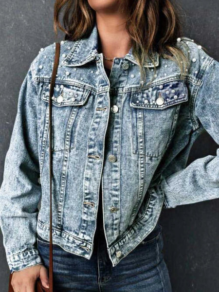 Denim jacket with embellishments on a plain background