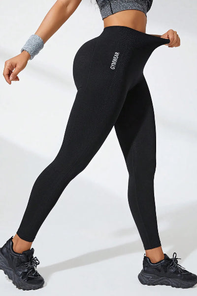 Person wearing black leggings with a brand logo on a white background