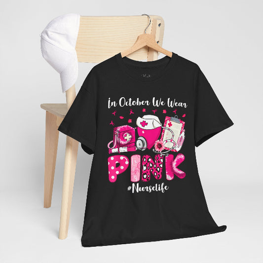 Black t-shirt with pink and white graphics and text on a wooden chair.