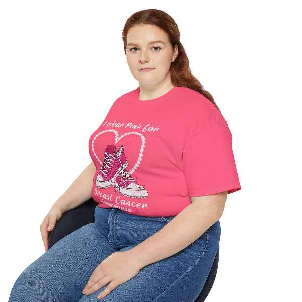 Person wearing a pink t-shirt with a heart and shoe design, sitting on a white background.