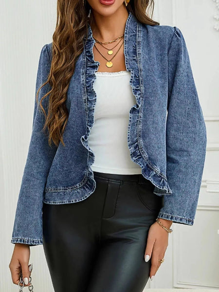 Woman wearing a denim jacket over a white top and black pants against a white background