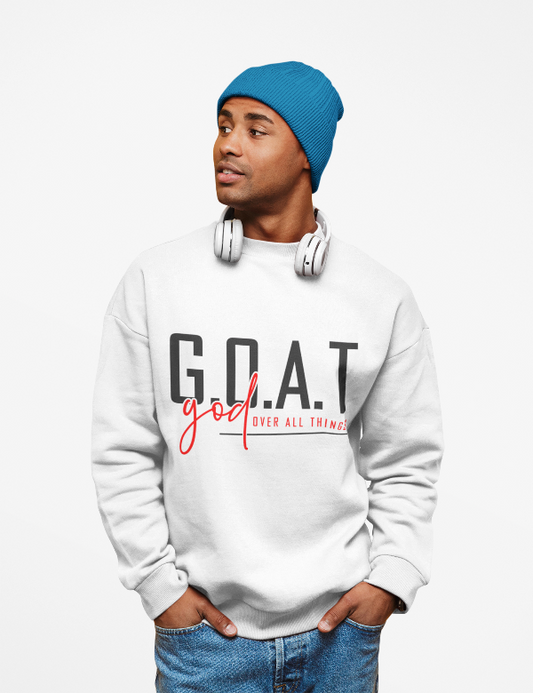 Man wearing a white sweatshirt with 'G.O.A.T. god over all things' text, blue beanie, and headphones on a white background