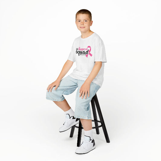 Child sitting on a stool wearing a 'Squad' t-shirt with a pink ribbon design.