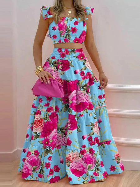 Woman wearing a floral two-piece outfit with a pink clutch against a light pink background