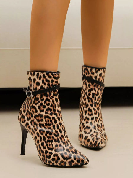 Leopard print ankle boots worn by a person on a neutral background